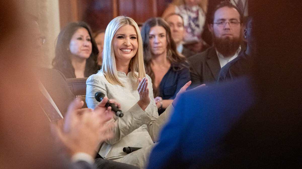 Ivanka Trump smiles and claps for a speaker at an event