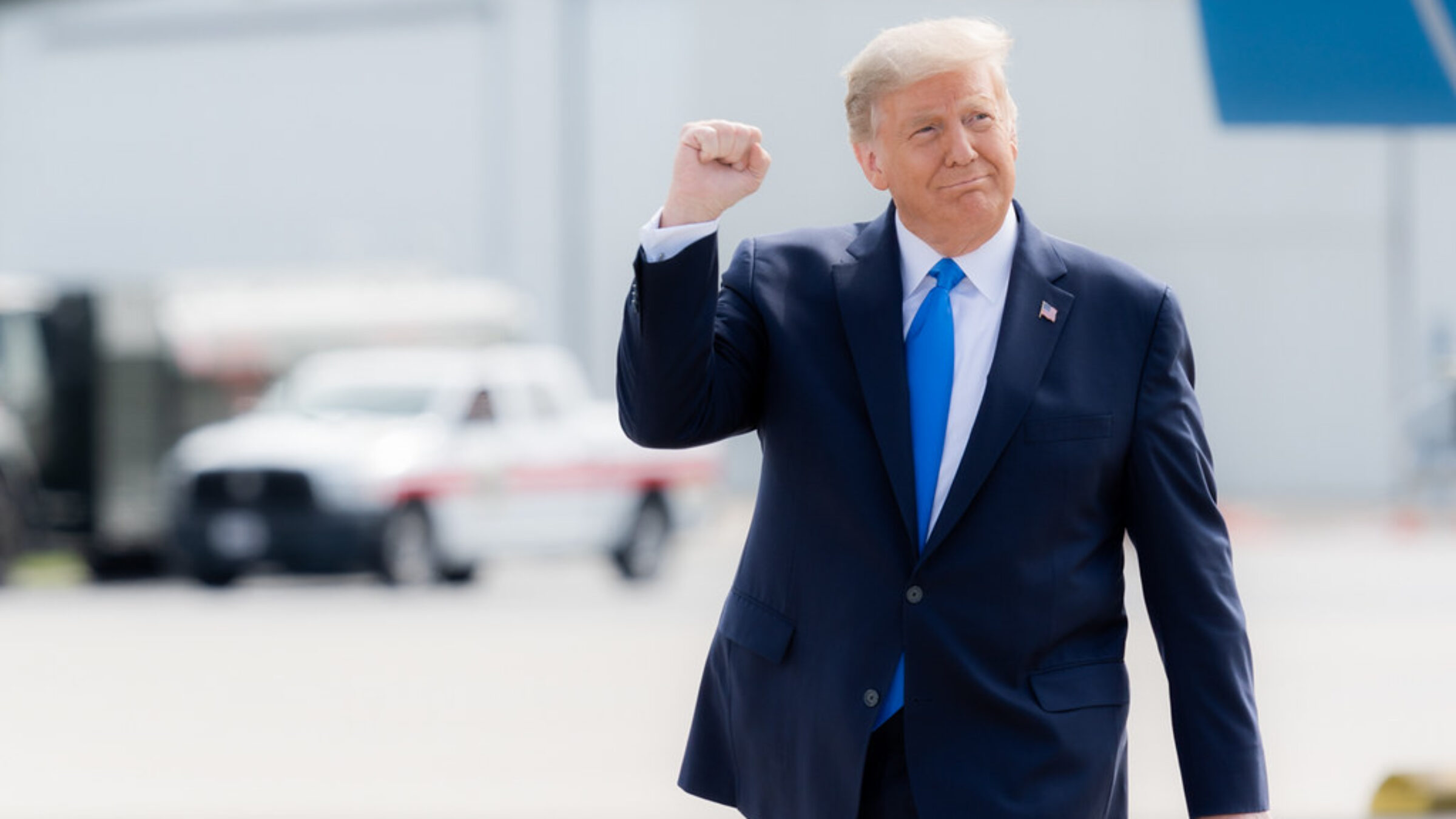 President Trump pumps his fist while walking across a tarmac