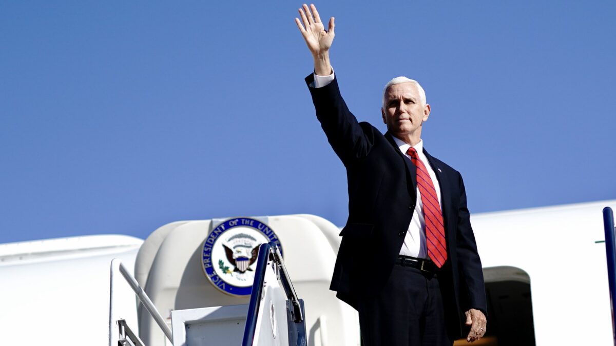 Mike Pence waves as he boards a flight.