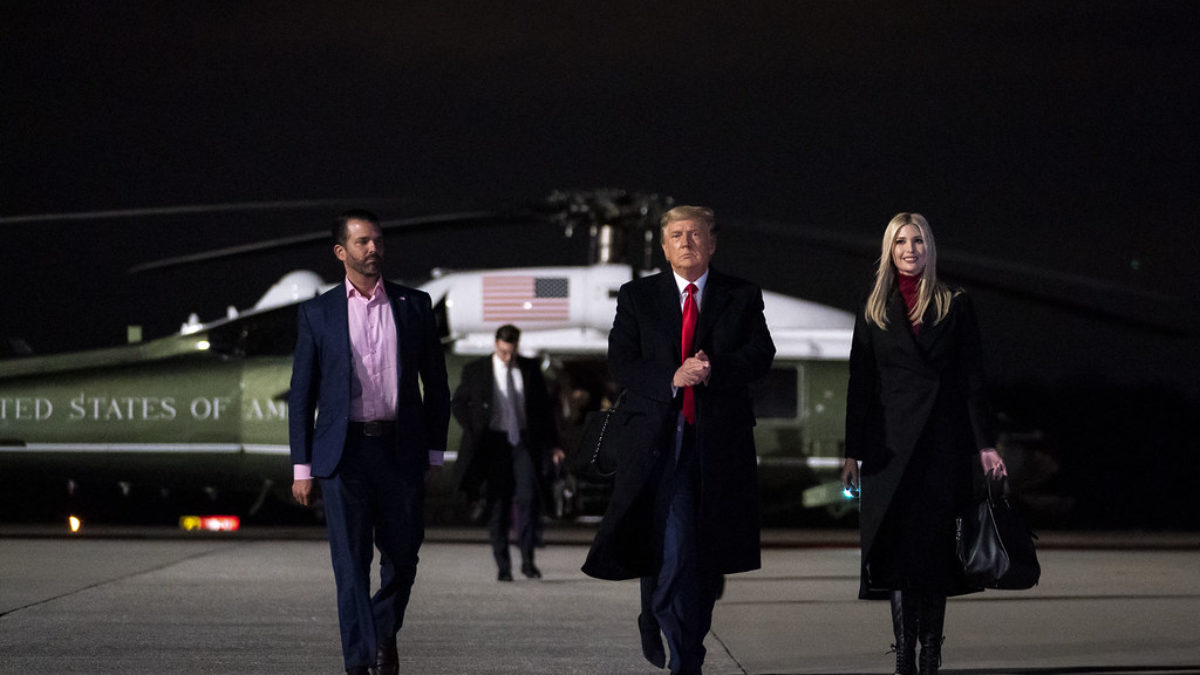 Donald Trump, Ivanka Trump, and Jared Kushner walk away from Marine One at night