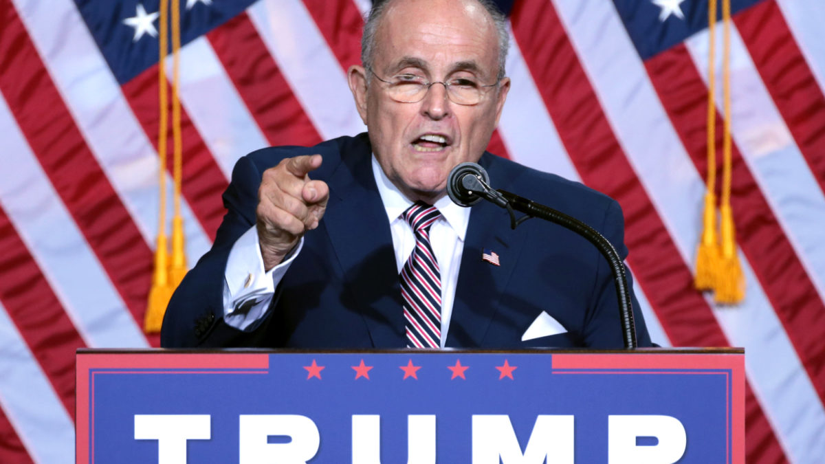 Rudy Giuliani speaks while pointing a finger at a Trump campaign event