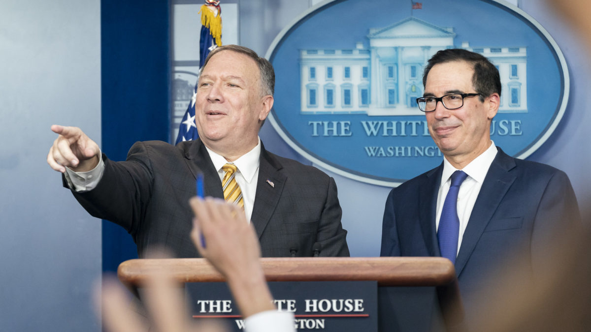 Mike Pompeo fields a question from a reporter while Steve Mnuchin stands beside him in the White House Press Briefing room