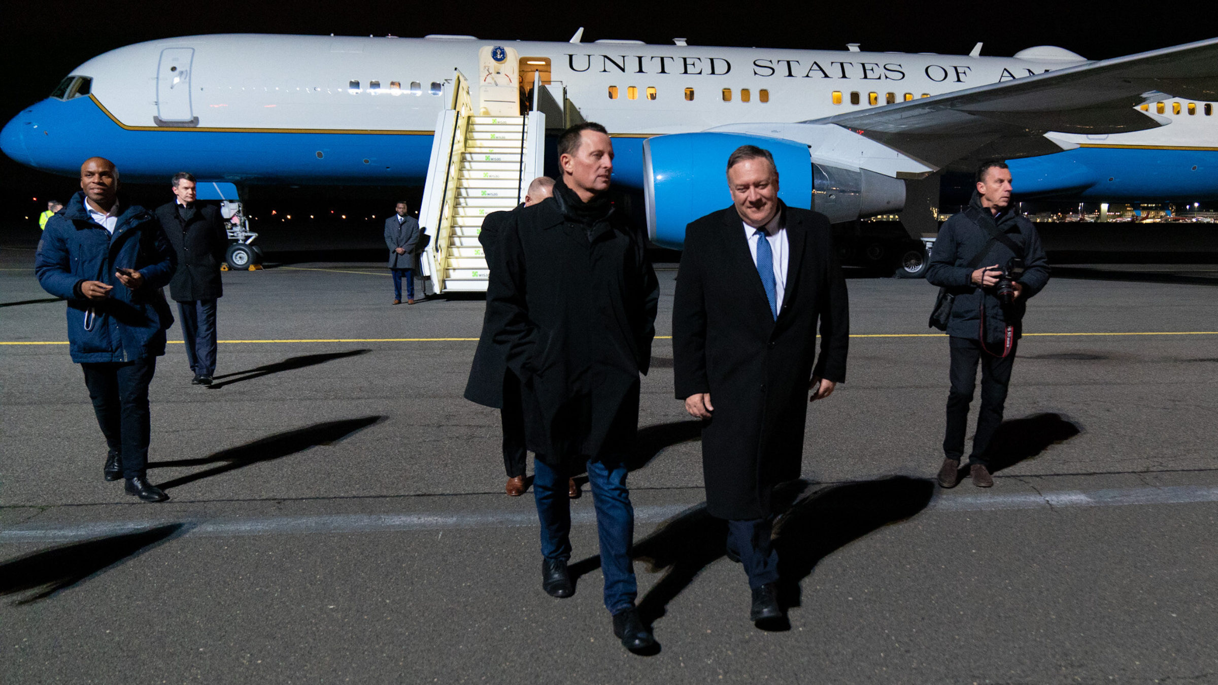 Mike Pompeo and Richard Grenell walk away from a plane resembling Air Force One