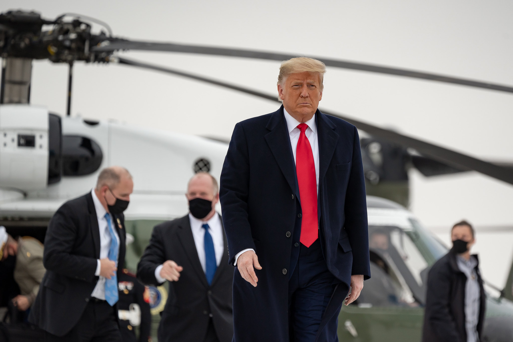 A stern-faced Donald Trump walks away from Marine One