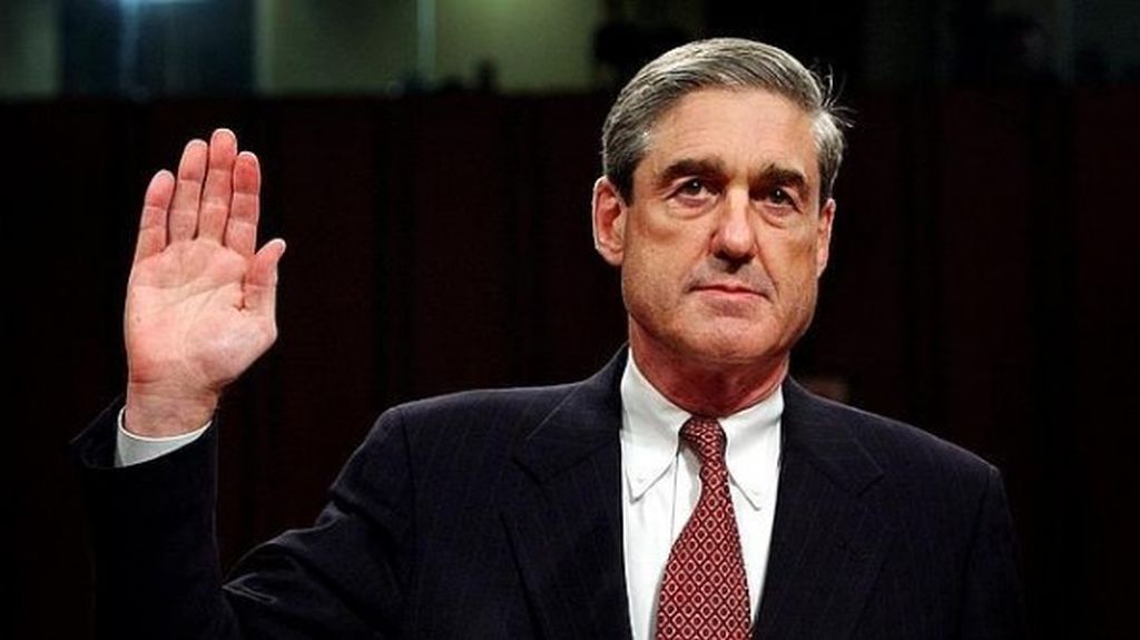 Robert Mueller holds his right hand up, taking an oath of office.