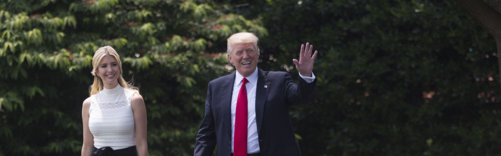 Donald Trump smiles and waves while Ivanka stands to the left of him