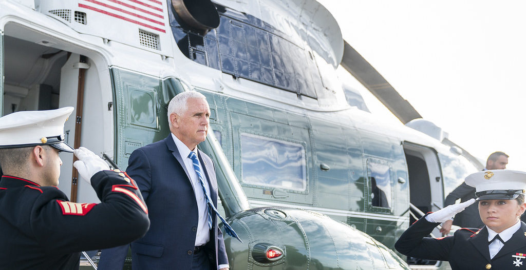 Mike Pence disembarks Marine Two with two saluting military officials at his sides
