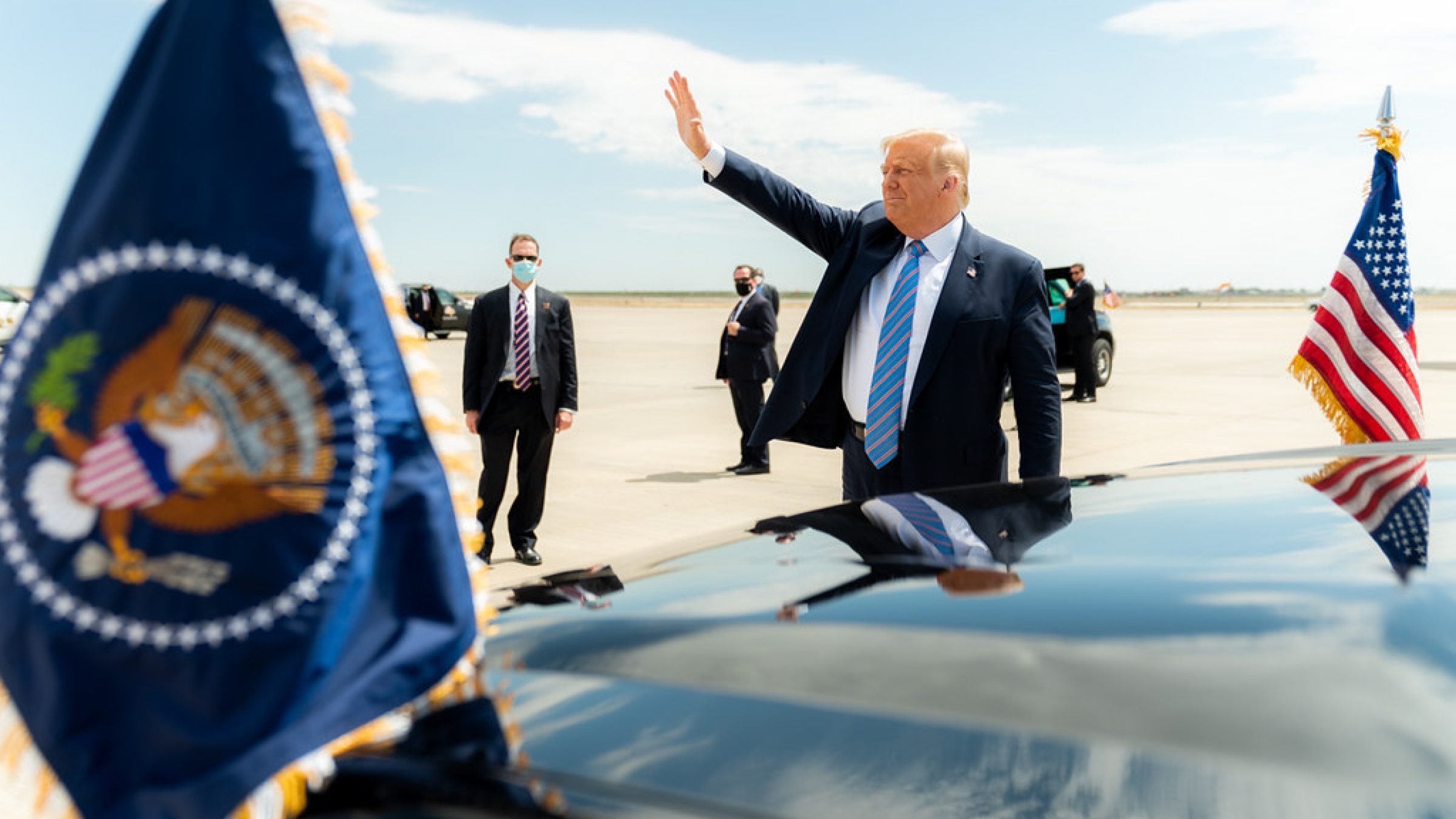 President Trump waves before stepping into his motorcade